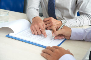 Contrato de adesão: comerciante indicando onde o consumidor deve assinar o contrato de adesão